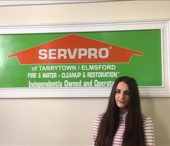 female employee in front of a SERVPRO sign