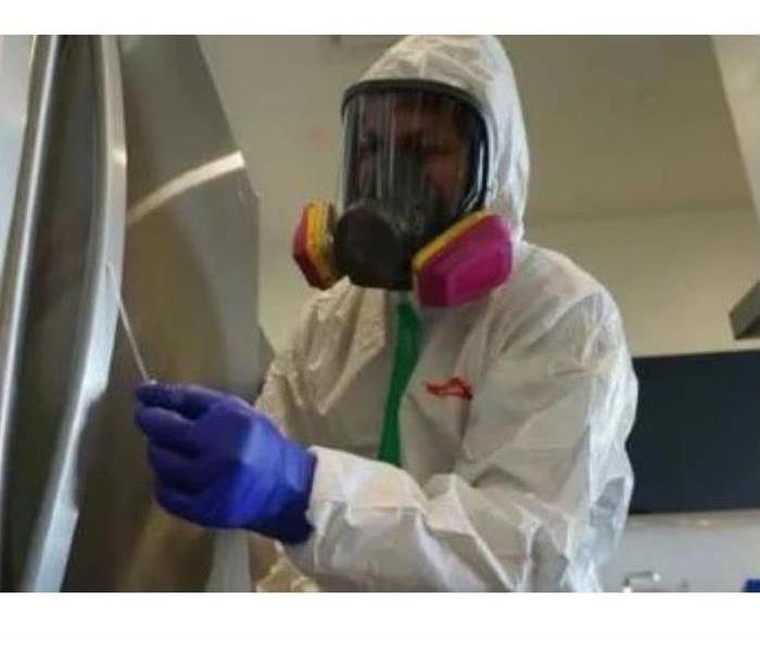 employee in white PPE gear